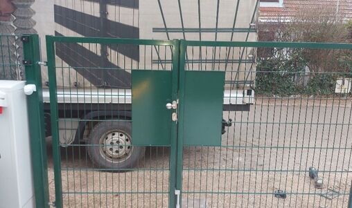 Modernes, elektrisches Schiebetor in grünem Metall-Design mit integriertem Briefkasten.